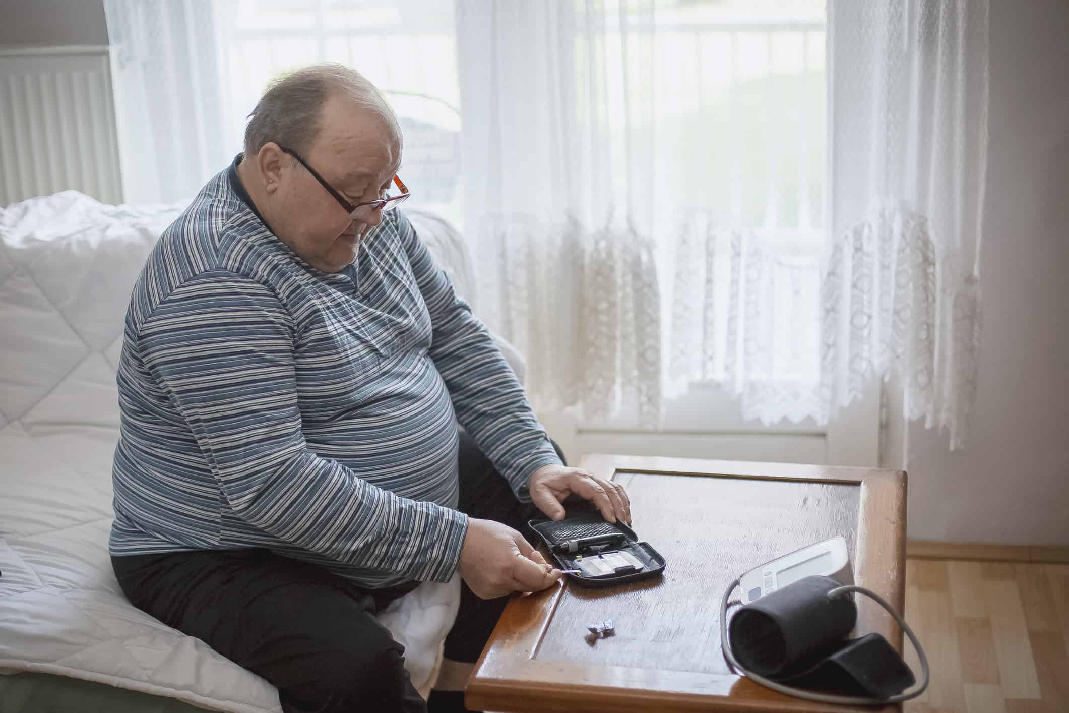 Senior man checking blood sugar levels